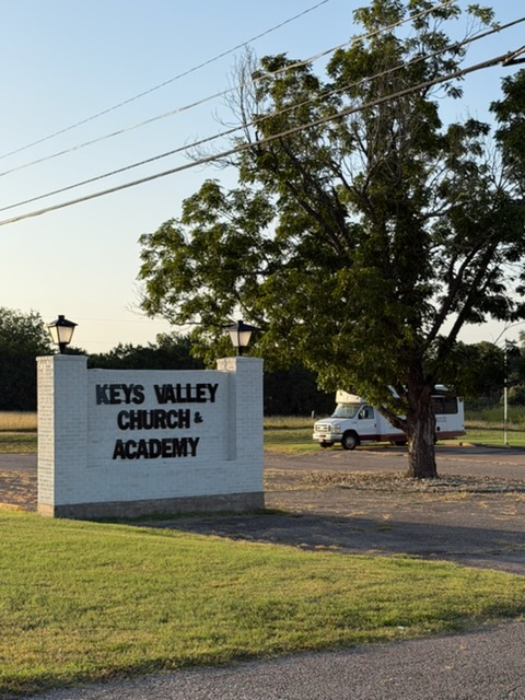 Church & Academy sign with oak tree at sunset